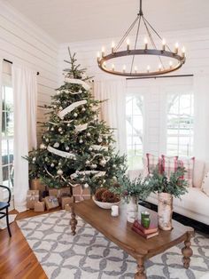 a living room filled with furniture and a christmas tree in the middle of the room