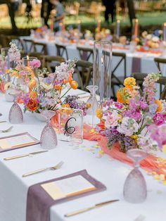 the table is set up with flowers and place settings for guests to sit down at