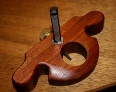 a close up of a wooden object on a table with a screwdriver in it