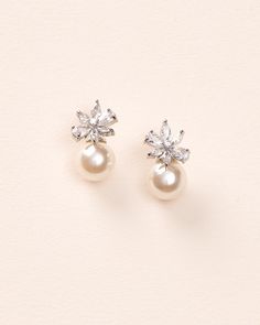 Feminine & floral with a dainty pearl accent, our Carmen Pearl Stud Earrings will be your new go-to pair. Perfect for brides & bridesmaids alike. Cubic zirconias & off white pearls Measures 0.75" Hypoallergenic, lead-free & nickel-free Style #4445 Formal Pearl White Flower Earrings With Pearl Drop, Delicate Pearl Charm Flower Earrings For Wedding, Delicate Pearl Bridal Earrings For Formal Occasions, White Cubic Zirconia Flower Earrings For Wedding, Formal Pearl White Flower Earrings, Dainty Cubic Zirconia Flower Earrings For Wedding, Classic Silver Flower Earrings For Wedding, Elegant Pearl Cluster Earrings For Wedding, Classic White Flower Earrings For Wedding