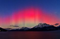 the aurora lights shine brightly in the sky above mountains