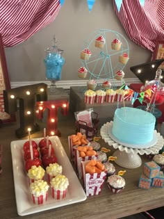 a carnival themed birthday party with cupcakes and candy bars on a table in front of a ferris wheel