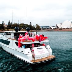 a white boat with balloons on it floating in the water