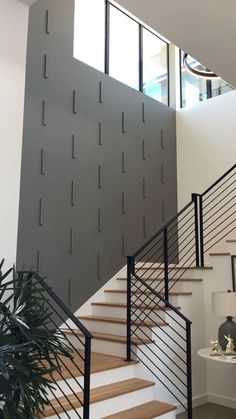 a stair case with metal railings and wooden steps in a modern style home setting