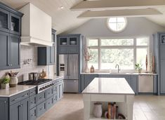 a large kitchen with gray cabinets and white counter tops