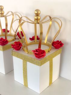 two white boxes with gold trim and red roses on them, one has a crown