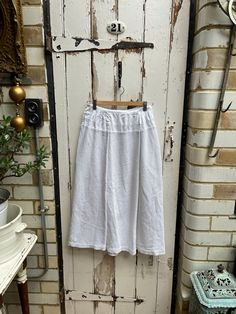 Antique French handmade white cotton waffle warm skirt size S. 100% Cotton. Flat front with handgathering at sides and back, subtle stripe in cotton at top and then waffle textured skirt, side opening, hook & eye fastening. Naive, peasant, country style skirt. Size:  Waist: 26 inches; Length: 31.5 inches. Weight: allow up to 1 kg once packed. Reasonable condition for its age - a couple of faint smudges on waffle front as shown and some stitching is coming on one seam on front but easily fixed; o White Relaxed Linen Skirt, White Linen Lined Skirt, White Gathered Skirt For Daywear, White Cotton Gathered Skirt, White Pleated Skirt For Daywear, White Cotton Full Skirt, White Cotton Lined Skirt, White Lined Skirt For Daywear, Summer Cotton Skirt With Unfinished Hem