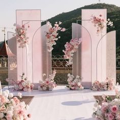 an outdoor wedding setup with pink and white flowers