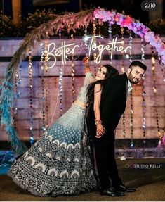 a man and woman standing in front of a sign that says better together