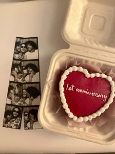 a heart shaped cake in a box with photos