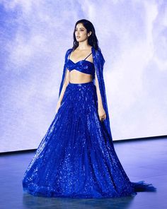 a woman in a blue dress on the runway