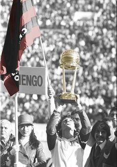 a man holding up a trophy in front of a crowd