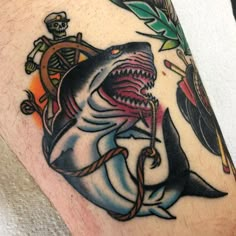 a man with a shark tattoo on his arm and an anchor in the other hand