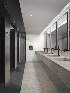 an empty public restroom with sinks and mirrors