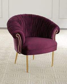 a purple chair sitting on top of a carpeted floor next to a white wall