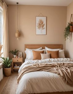 a bedroom with a large bed and potted plants