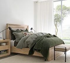 a bedroom with a bed, nightstand and window