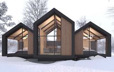 three small wooden houses in the snow with windows on each side and an upper floor