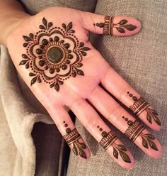 a woman's hand with henna tattoos on it