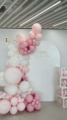 the balloon arch is decorated with pink and white balloons for a baby's first birthday