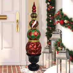 a red and green christmas ornament sitting in front of a door