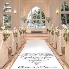 the aisle is decorated with white flowers and greenery