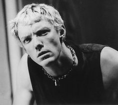 black and white photograph of a young man with blonde hair wearing a chain around his neck