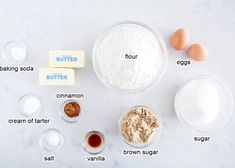 ingredients to make an egg cake laid out on a white counter top, including flour, butter, eggs, cinnamon, sugar, and brown sugar