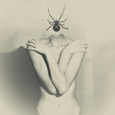 a black and white photo of a naked woman with a spider on her head above her head