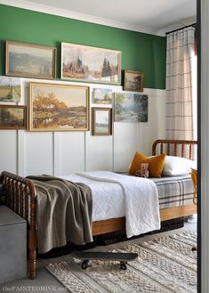 a bedroom with green walls and pictures on the wall