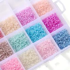 small beads in a plastic container on a white surface