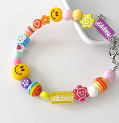 a child's bracelet with smiley face beads and nameplates on the clasp