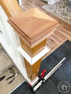 a wooden post in the middle of a room with tools on the floor next to it