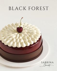 there is a cake with a cherry on top and the words black forest above it