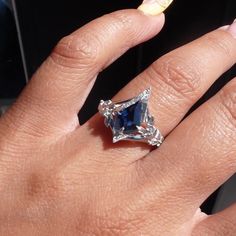 a woman's hand with a ring on it and a blue stone in the middle