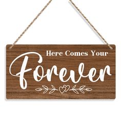 a wooden sign with the words here comes your forever on it hanging from a rope