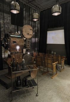 an old fashioned movie projector and chairs in a room