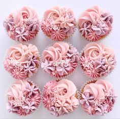 twelve cupcakes with pink frosting and flowers on them are arranged in rows