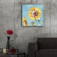 a living room with a couch, table and two sunflowers on the wall