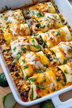 a casserole dish with zucchini, black beans, cheese and other toppings