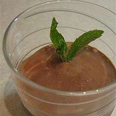 a glass filled with chocolate pudding on top of a table