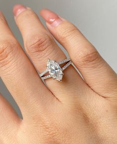 a woman's hand with a diamond ring on top of her finger and an engagement band