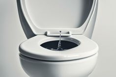 a white toilet with the lid up and water coming out