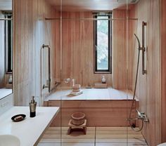 a bathroom with a tub, sink and shower in the corner next to two sinks