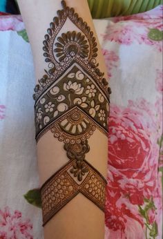 a woman's arm with henna tattoos on it