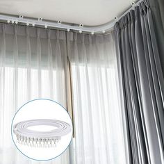 the curtain rod is hanging from the ceiling in front of sheer curtains with fringes on them