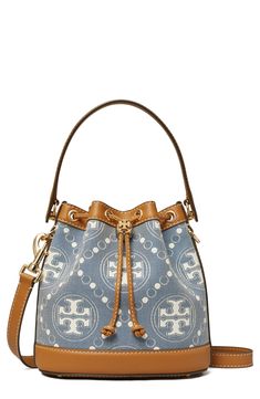 Logo-patterned denim and smooth leather provide textural interplay on this bucket bag featuring a drawstring closure cinched with a logo-embellished toggle. Drawstring closure Top carry handle; removable, adjustable crossbody strap Exterior slip pocket Interior wall pocket Protective metal feet Lined Cotton with leather trim Imported Tan Bucket Bag With Handles, Travel Bucket Bag With Branded Hardware, Casual Bucket Bag In Coated Canvas, Casual Coated Canvas Bucket Bag, Casual Bucket Shoulder Bag In Coated Canvas, Casual Coated Canvas Bucket Shoulder Bag, Blue Bucket Bag With Gold-tone Hardware, Blue Canvas Bucket Bag, Tan Leather Handle Bucket Bag