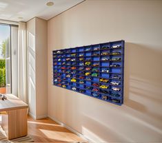 a room with a table and some toy cars on the wall next to a window