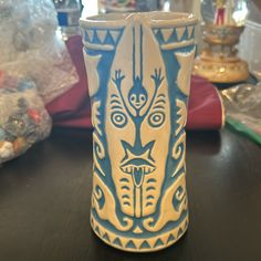 a blue and white vase sitting on top of a wooden table next to other items