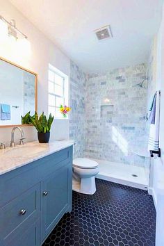 a white toilet sitting next to a bath tub under a window in a bathroom with black and white floor tiles